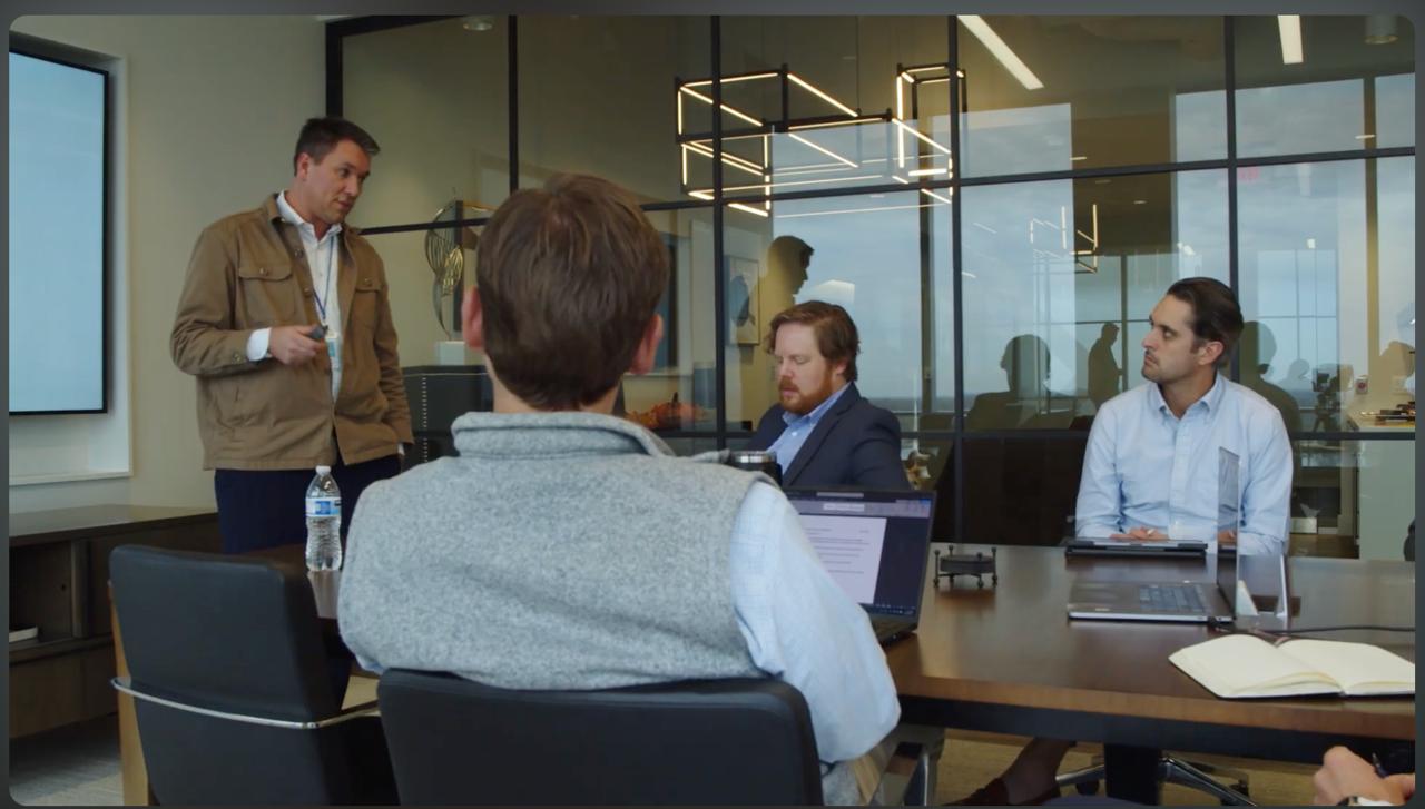Vance Crowe teaching a small group of executives around a boardroom table